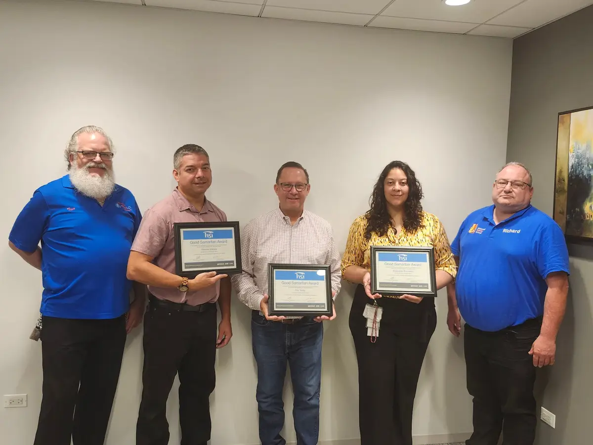 Five people standing together with framed certificates