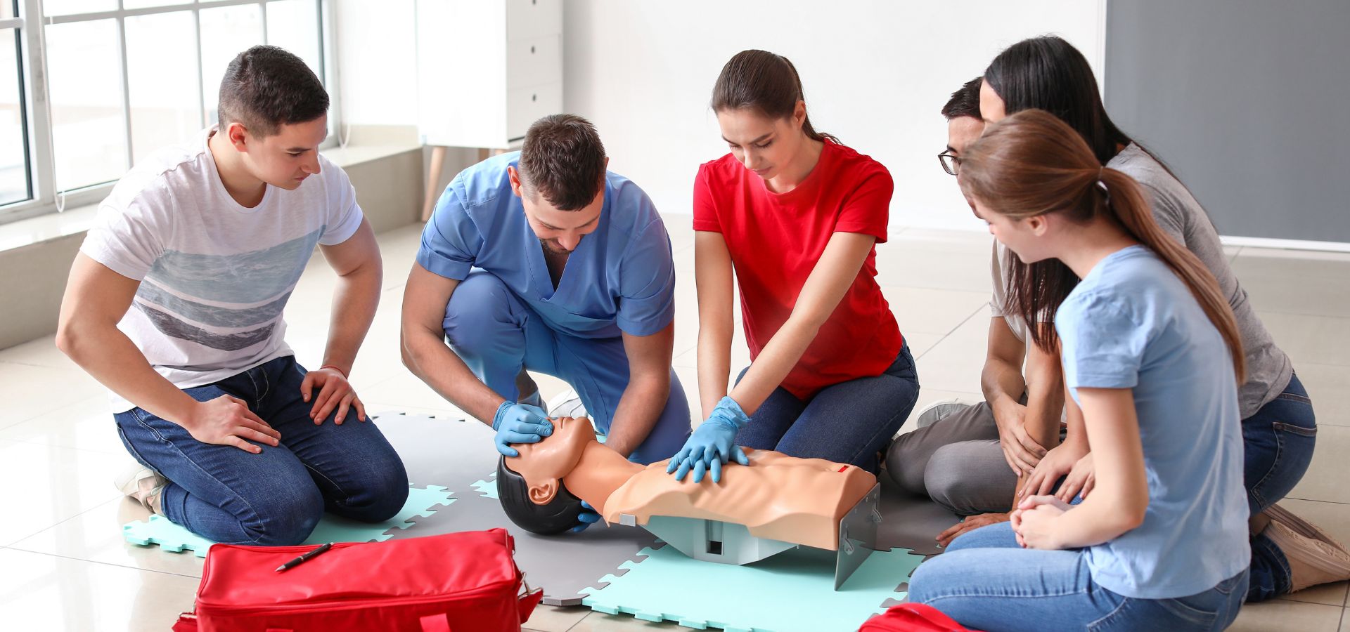 Instructor coaching a student through CPR on a training manikin